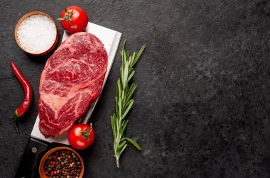 Taştan bir arka planda et bıçağında çiğ mermer biftek.