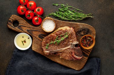 Biftek ızgarası ve taştan arka planda et bıçağının malzemeleri.