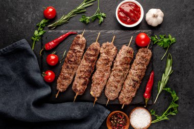 Lezzetli ızgara Lula kebapları şiş ve baharatlar arka planda.