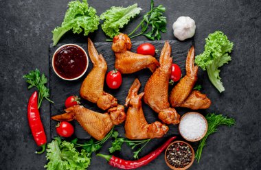 Taş zeminde baharatlı tütsülenmiş tavuk kanadı.