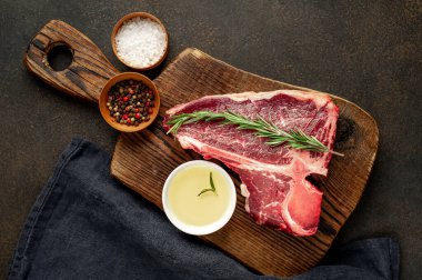 Bifteğin, taştan arka plandaki kesme tahtasındaki malzemelerle yakın plan görüntüsü.