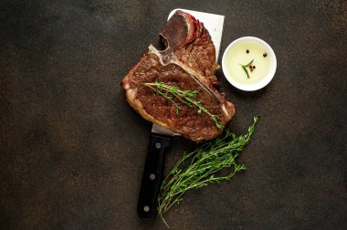 Biftek ızgarası ve taştan arka planda et bıçağının malzemeleri.