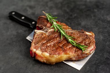 Biftek ızgarası ve taştan arka planda et bıçağının malzemeleri.