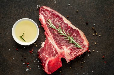 Taştan arka planda et bıçağındaki malzemelerle birlikte çiğ biftek yakın plan görüntüsü.