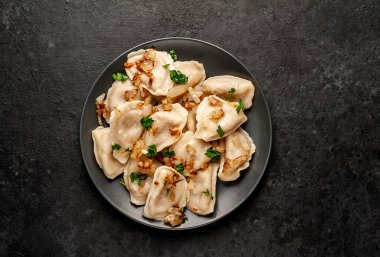 Taştan bir arka planda haşlanmış lahana ile doldurulmuş hamur tatlısı.