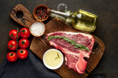 Bifteğin, taştan arka plandaki kesme tahtasındaki malzemelerle yakın plan görüntüsü.