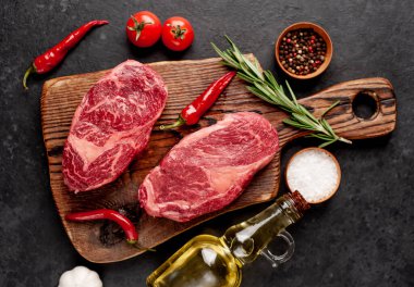 Arka planda baharatlı iki çiğ biftek.