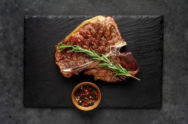 Yakından bakınca, taştan arka planda malzemelerle lezzetli ızgara biftek.