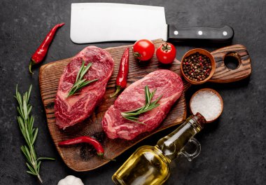 Arka planda baharatlı iki çiğ biftek.