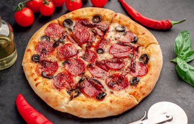 Salamlı pizza pepperonisi, mozarella, zeytin, arka planda Provencal otlar.