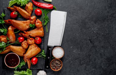 Taş zeminde baharatlı tütsülenmiş tavuk kanadı.