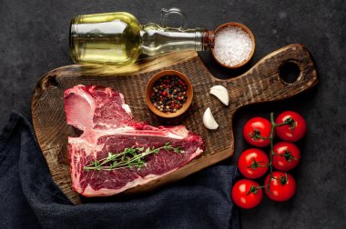 Bifteğin, taştan arka plandaki kesme tahtasındaki malzemelerle yakın plan görüntüsü.