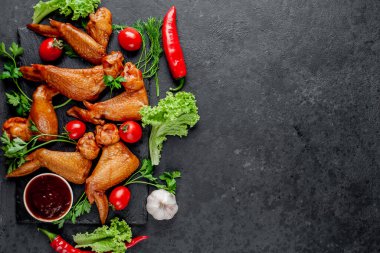 Taş zeminde baharatlı tütsülenmiş tavuk kanadı.