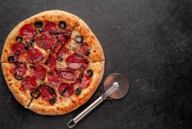 Salamlı pizza pepperonisi, mozarella, zeytin, arka planda Provencal otlar.