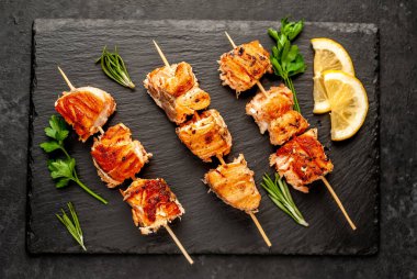 Koyu taş arka planda ızgara somon kebabı.