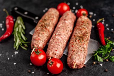 Çiğ Lula kebabı şiş üstünde et bıçağının üzerinde baharat taştan arka planda.