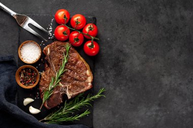 Yakından bakınca, taştan arka planda malzemelerle lezzetli ızgara biftek.