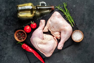 Baharatlı tavuk budu, biber biberi ve siyah taş arka planda biberiye dalları.