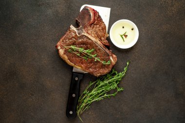 Biftek ızgarası ve taştan arka planda et bıçağının malzemeleri.