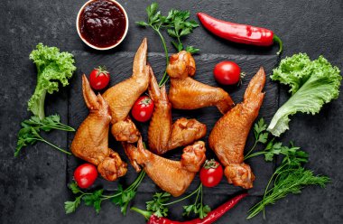 Taş zeminde baharatlı tütsülenmiş tavuk kanadı.