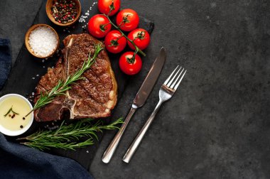 Yakından bakınca, taştan arka planda malzemelerle lezzetli ızgara biftek.