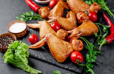 Taş zeminde baharatlı tütsülenmiş tavuk kanadı.