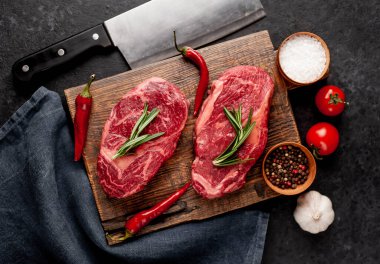 Arka planda baharatlı iki çiğ biftek.