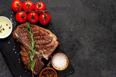 Yakından bakınca, taştan arka planda malzemelerle lezzetli ızgara biftek.