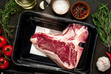 Taştan arka plandaki hava geçirmez gıda kutusundaki çiğ biftek yakın plan görüntüsü.