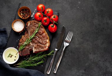 Yakından bakınca, taştan arka planda malzemelerle lezzetli ızgara biftek.