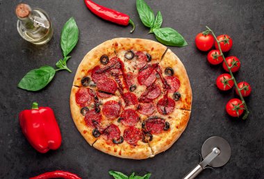 Salamlı pizza pepperonisi, mozarella, zeytin, arka planda Provencal otlar.