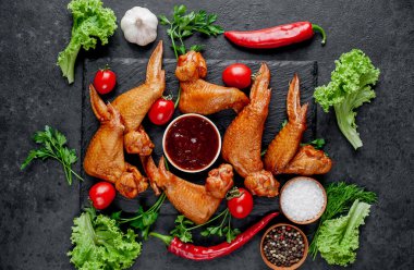 Taş zeminde baharatlı tütsülenmiş tavuk kanadı.