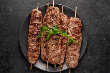 Lezzetli ızgara Lula kebapları şiş ve baharatlar arka planda.