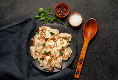 Taştan bir arka planda haşlanmış lahana ile doldurulmuş hamur tatlısı.