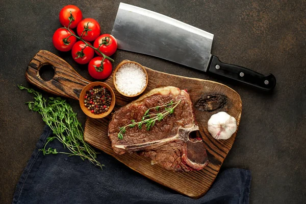 Biftek ızgarası ve taştan arka planda et bıçağının malzemeleri.