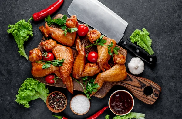 Smoked chicken wings with spices on a stone background