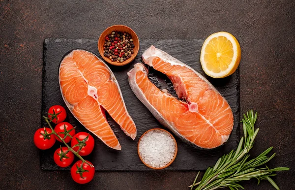 Çiğ balık somon bifteği ve taştan bir arka planda malzemeler.