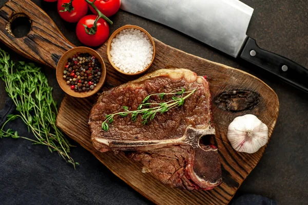 Biftek ızgarası ve taştan arka planda et bıçağının malzemeleri.