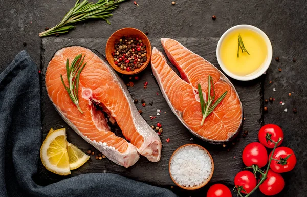 Çiğ balık somon bifteği ve taştan bir arka planda malzemeler.