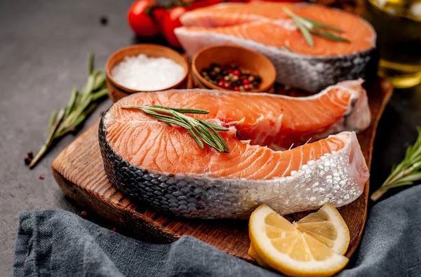 Close Blik Rauwe Zalmsteaks Met Ingrediënten Snijplank Een Stenen Achtergrond — Stockfoto