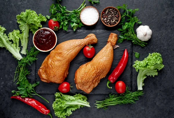 Arka planda baharat olan tütsülenmiş tavuk butları.