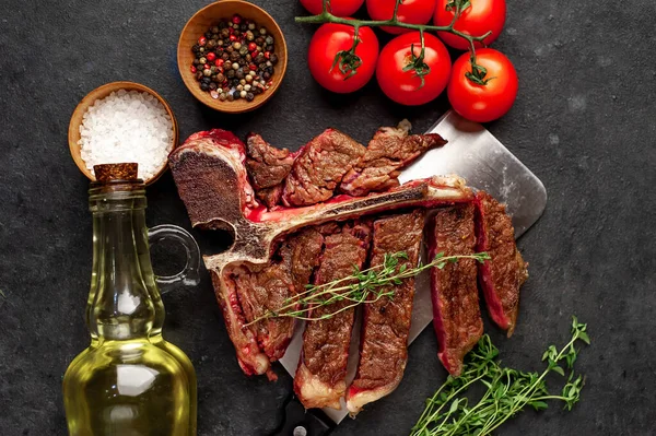grill t-bone steak with ingredients on stone background