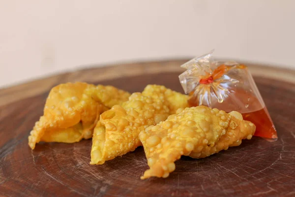 Bolinhos fritos, comida chinesa com molho em saco plástico em madeira — Fotografia de Stock