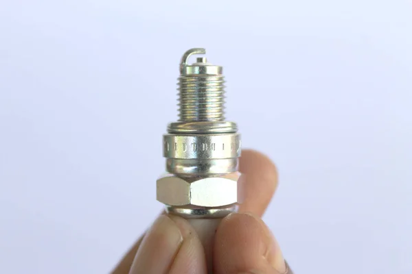 New spark plug in hand before use.