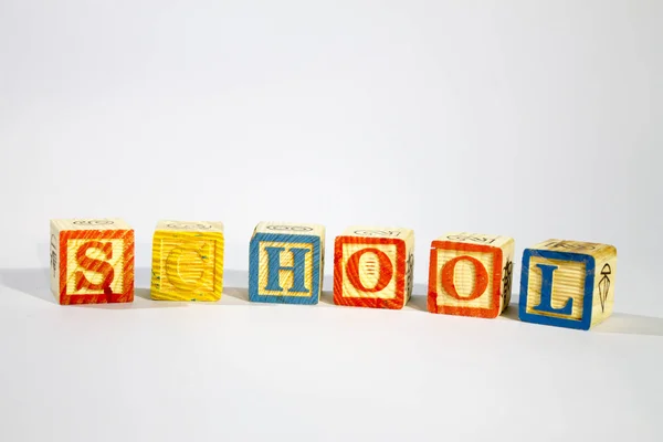 Wooden Alphabet Blocks spell SCHOOL in horizontal.