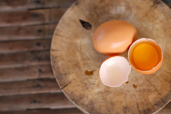 Καστανά αυγά σε ξύλινη σανίδα κοπής υπάρχει ένας κρόκος στο αυγό Εικόνα Αρχείου