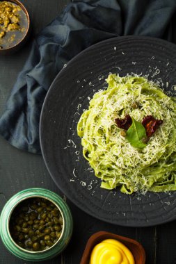 Pesto ve Parmesan peyniri bir plaka üzerinde bir karanlık adam tarih yapıştırın