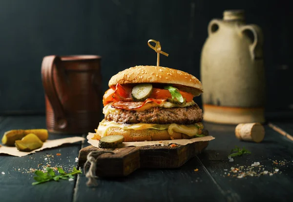 Delicious burger with meat and ingredients on a dark background