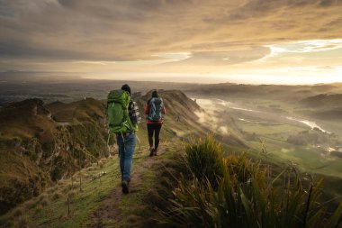 Backpackers walking on a mountain during sunrise. Te Mata Peak. Hawkes Bay. New Zealand clipart