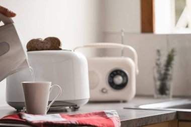 Elektrikli su ısıtıcısı, tost makinesi ve eski model radyoyla kahvaltı zamanı. Beyaz arkaplan